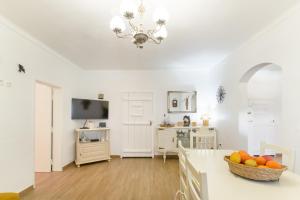 a white living room with a bowl of fruit on a counter at Celestial Melides Country House in Melides