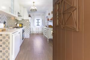 a kitchen with white cabinets and a wooden floor at Celestial Melides Country House in Melides +20 photos