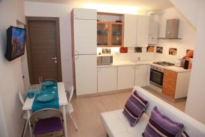 拉瓦尼亞的住宿－甜蜜之家民宿，厨房配有白色橱柜和桌椅