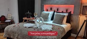 a bedroom with a bed with two white towels on it at Le Carpe Diem - Détente & Bien-être - Balnéo, Sauna, CLIM, Terrasse, Parking privé in Dole +30 photos