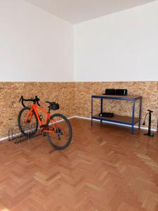 an orange bike parked in a room with a table at Fioralpino Apartments in Sospirolo