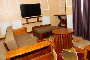 a living room with a flat screen tv and a couch at Kinyuki Country Hotel in Nanyuki