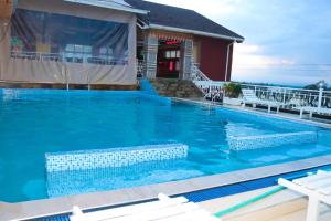 a swimming pool with blue water in front of a house at Kinyuki Country Hotel in Nanyuki