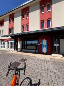 an orange bike parked in front of a building at Fioralpino Apartments in Sospirolo