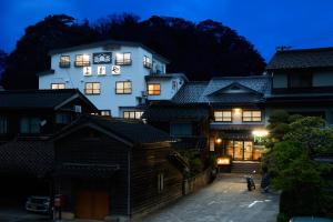 a white building with a clock on it at night at Yodoya in Toyooka