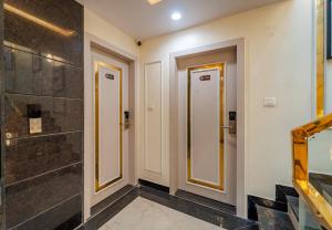a bathroom with two doors and a shower at Treebo Vistara Gold Ujjain Junction in Ujjain
