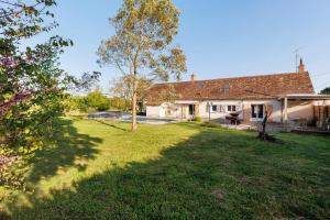 a backyard of a house with a tree at Longère Pierre De Ronsard piscine in Rilly-sur-Loire