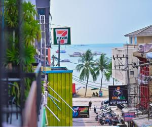 a view of a street with a yellow building and the beach at Destination Boutique Hotel in Pattaya