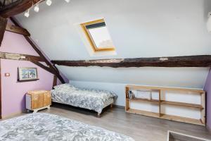 a attic bedroom with two beds and a window at Longère Pierre De Ronsard piscine in Rilly-sur-Loire +26 photos