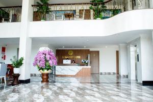 a lobby of a hotel with purple flowers at Sunflower Hotel in Nhơn Trạch