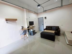 a living room with a couch and a desk at Lynn Living (ลินน์ ลิฟวิ่ง) in Ban Non Muang