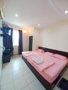 a bedroom with two beds with pink sheets at Intanova Hotel in Teluk Intan