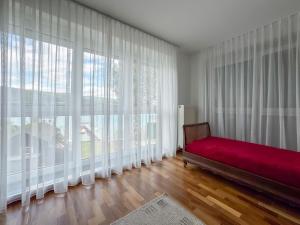 a room with a red couch in front of large windows at Ferienhaus Pippan in Velden am Wörthersee +44 photos