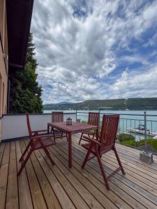 a wooden deck with a table and two chairs at Ferienhaus Pippan in Velden am Wörthersee