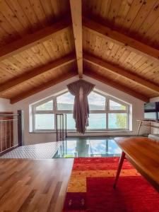 a living room with a large window and a wooden ceiling at Ferienhaus Pippan in Velden am Wörthersee