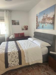 a bedroom with a bed and a painting on the wall at stazione Lina house in Mestre