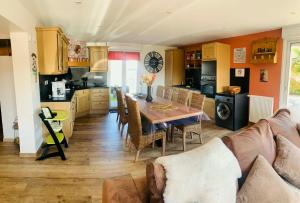 a kitchen and living room with a table and a couch at Résidence Les beaux jours in Neufchâtel-Hardelot