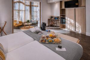 a hotel room with a bed with a tray of food on it at Hotel SERHS Rivoli Rambla in Barcelona