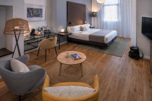 a hotel room with a bed and a table and chairs at Hotel SERHS Rivoli Rambla in Barcelona +139 photos