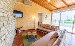 a living room with a couch and a stone wall at Gîtes Les 2 Fontaines in Marans