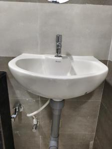 a white sink on a wall in a bathroom at Sekar Inn in Arumuganeri +18 photos