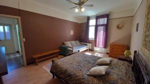 a bedroom with a bed and a couch and a window at Chez Valérie côté Sud in Saint-Jean-du-Gard