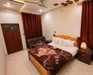 a bedroom with a large bed with a brown blanket at Second Home Hotel in Multan
