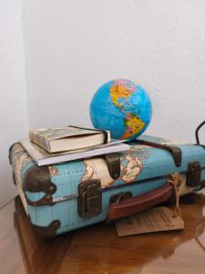 a blue suitcase with a globe sitting on top of it at Indigo Moon in Quartu SantʼElena