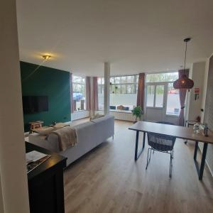 a living room with a couch and a table at 't Westeind, Modern en sfeervol appartement in Norg in Norg