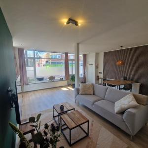 a living room with a couch and a table at 't Westeind, Modern en sfeervol appartement in Norg in Norg