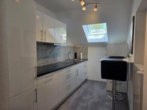 a kitchen with white cabinets and a skylight at Tifra-living in Hardenberg