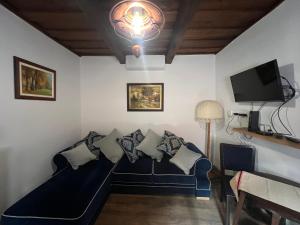 a living room with a blue couch and a tv at Bedi Vendégház in Nagybakónak