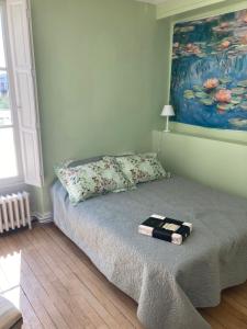 a bed in a bedroom with a painting on the wall at Superbe maison calme au centre ville in Blois