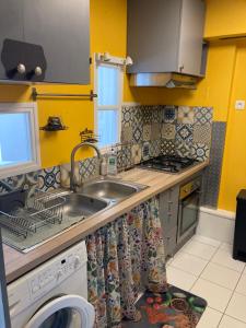 a kitchen with a sink and a washing machine at Superbe maison calme au centre ville in Blois +15 photos