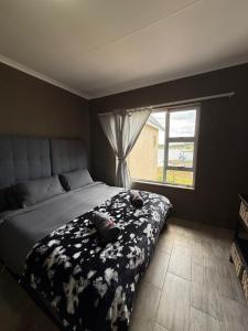 a bedroom with a bed with a black and white blanket at Marina stunning escape in Jeffreys Bay