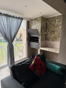 a couch sitting in a living room with a window at Marina stunning escape in Jeffreys Bay