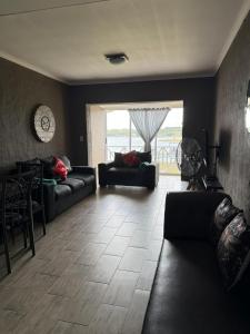 a living room with two couches and a table at Marina stunning escape in Jeffreys Bay +1 photo