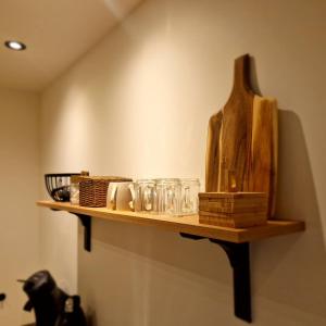 a wooden shelf on a wall with glasses on it at 't Westeind, Modern en sfeervol appartement in Norg in Norg +5 photos