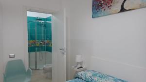a bathroom with a shower and a bed and a toilet at Komodo Rooms in Agropoli