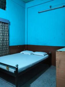 a bed in a room with a blue light at Oasis Lodge in Jorhat +23 photos