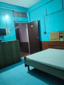 a hospital room with a bed and a door at Oasis Lodge in Jorhat