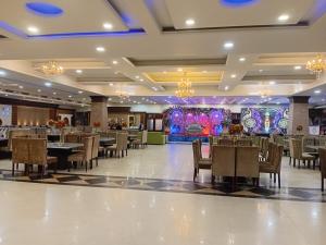 a banquet hall with tables and chairs and chandeliers at Hotel The Mirage in Gil +14 photos