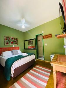 a bedroom with a bed and green walls at Hospedaria Estrada Real in Tiradentes