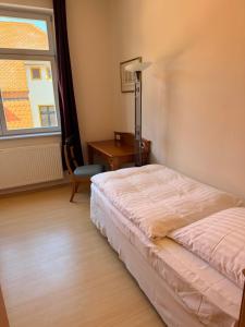 a bedroom with a bed and a desk and a window at Stiftung Kloster und Kaiserpfalz Memleben in Kaiserpfalz