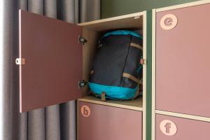 a cupboard with a backpack inside of it at MEININGER Hotel Berlin Mitte in Berlin