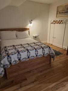 a bedroom with a bed with a comforter on it at Darrell Cottage in Kanturk