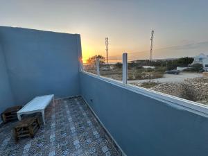 a balcony with a bench and a view of a parking lot at Charming room with balcony and ocean view in Essaouira