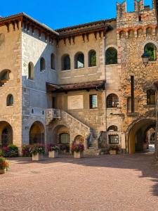 a large stone building with flowerpots in a courtyard at San Rocco Apartments 2 in Riva del Garda