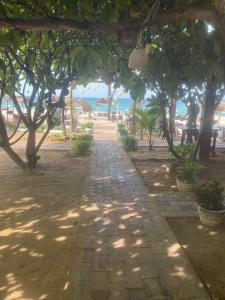 a pathway with trees and the ocean in the background at D & D Beach Resort in Trincomalee