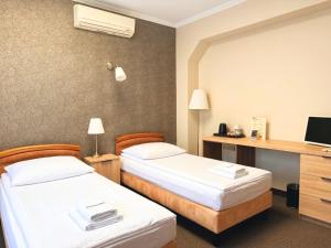 a hotel room with two beds and a desk at Noclegi-Restauracja Boss in Mogilno